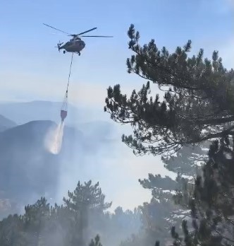 Muğla’nın Fethiye ilçesinde sarp arazide çıkan orman yangınını söndürmek için